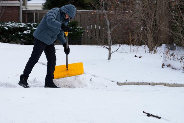 <p>A person cleans snow during a cold weather in Evanston, Illinois </p>